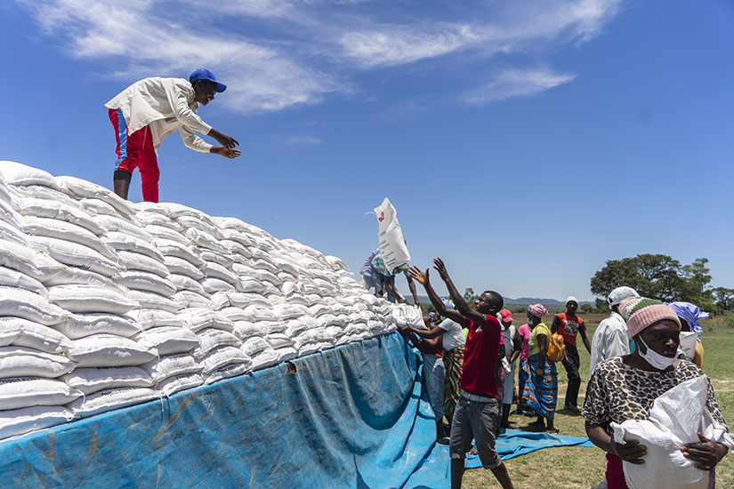 Young people from Denhere village in Zimbabwe offloading mealie meal from a truck