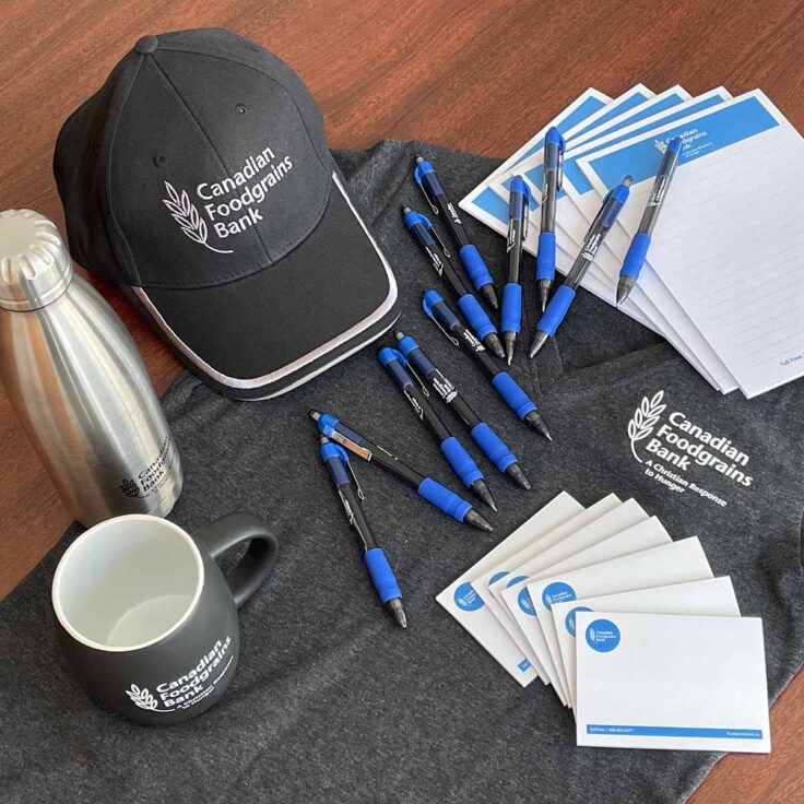 Merchandise including a shirt, hat, mug, water bottle, pens and notepads