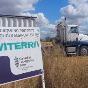 Truck driving through field behind Viterra sign
