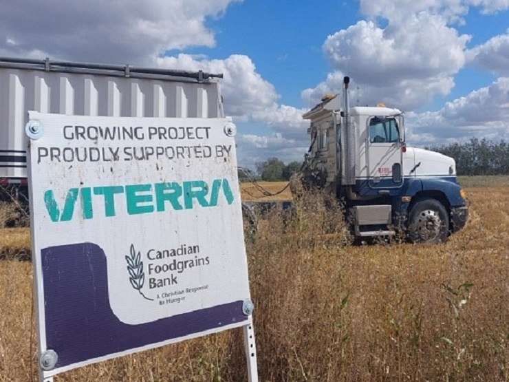 Truck driving through field behind Viterra sign