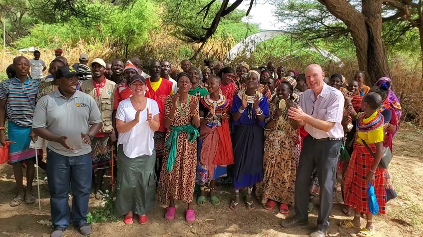 A group of people standing and clapping