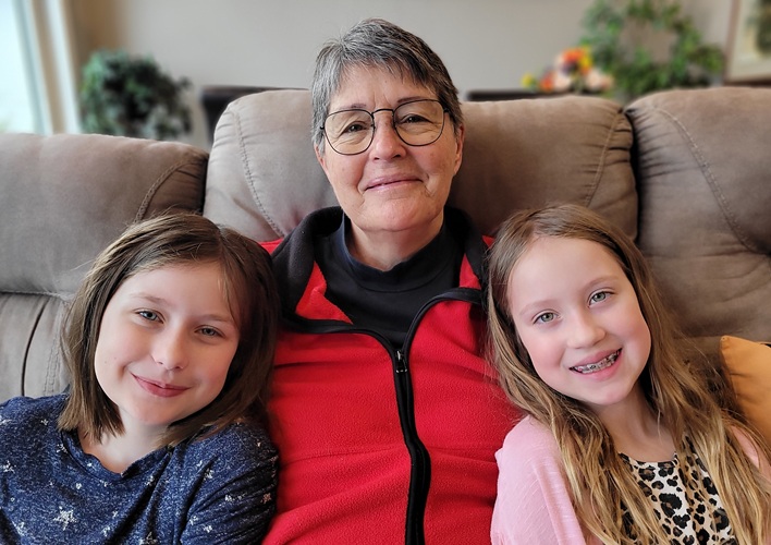 Two grandchildren sitting with their grandmother.